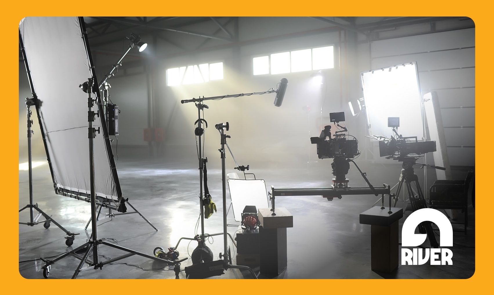 Professional videography equipment and lighting gear inside a professional film studio located in New Hampshire with an orange border on all sides.