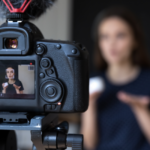 Woman speaking behind camera being filmed