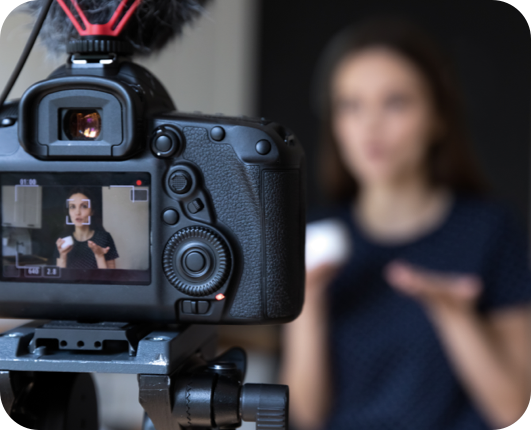 Woman speaking behind camera being filmed